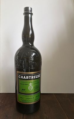 une bouteille de vin posée sur une table devant un mur