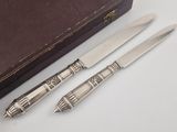 two knives and a knife holder on a table