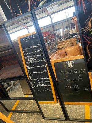 a woman standing in front of a blackboard menu