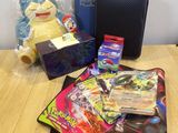 un jeu de cartes à collectionner Pokémon posé sur une table, à côté d'une boîte de cartes