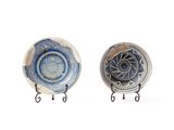 deux assiettes ornées de motifs, posées sur un support