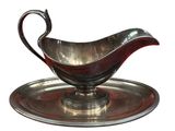 a silver plate with a silver gravy on it