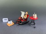 a miniature figurine of a man sitting in a rocking chair