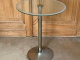 a glass table with a metal base and a glass top