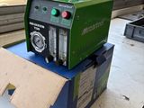 a green machine sitting on top of a box on a table