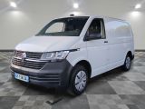 Une camionnette blanche est garée dans une pièce au sol en damier.