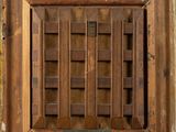 a close up of a wooden window with a metal grate in it