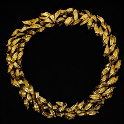 un collier en or orné de feuilles sur fond noir