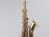 un gros plan d'un saxophone sur fond blanc