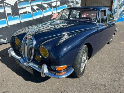 une photo d'une voiture bleue garée devant un immeuble