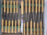 a lot of knives in a box with yellow handles