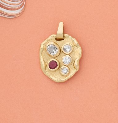 deux pendentifs en or sertis de diamants et ornés d'un coquillage sur fond rose