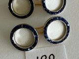 trois paires de boutons de manchette en émail bleu et blanc posés sur un tissu blanc