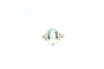 une bague ovale sertie d'une aigue-marine et de diamants, sur fond blanc