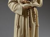 figurine représentant un moine tenant un enfant dans ses bras