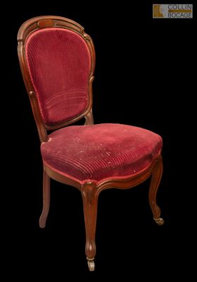 une image représentant une chaise dont l'assise est recouverte d'un tissu rouge, sur fond noir