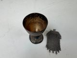 a small metal object sitting next to a small metal object