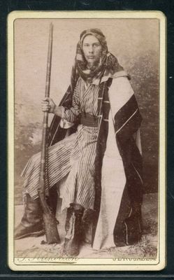 une vieille photo en noir et blanc d'une femme tenant un fusil