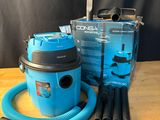 un gros plan d'un aspirateur bleu posé sur une table en bois