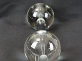 two clear glass vases sitting on a black surface