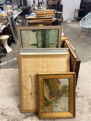 beaucoup d'œuvres d'art, encadrées ou non, posées par terre
