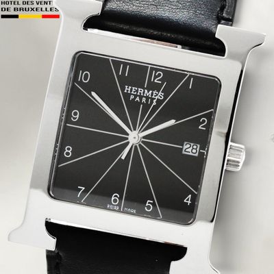 a black and silver square watch on a black leather strap