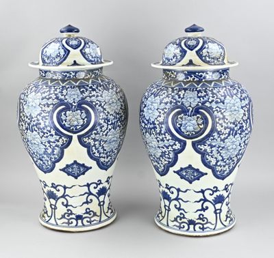 une paire de vases bleus et blancs avec couvercles, sur fond gris