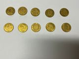 a bunch of gold coins sitting on top of a white table