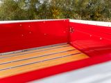 a red truck with a wooden bed in the back of it