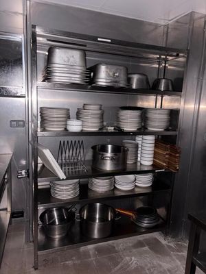 beaucoup d'assiettes et de casseroles sur les étagères de la cuisine