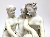 a statue of three women sitting on a bench