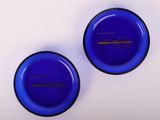 paire de bols en verre bleu avec des bords noirs sur une surface blanche