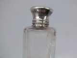 a small glass bottle with a silver lid on a table