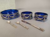 three blue bowls and spoons sitting next to each other