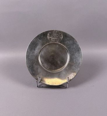 a silver plate with a lion on it on a stand