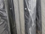 de nombreux matelas emballés dans des sacs en plastique dans un entrepôt