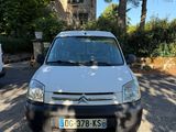 la camionnette blanche est garée sur le parking à côté des arbres