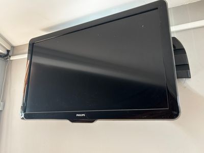 un téléviseur à écran plat fixé au mur d'une pièce