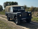 une Land Rover noire roulant sur un chemin de terre