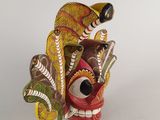 an image of a colorful wooden mask with a bird on it ' s head