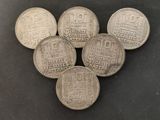 five silver coins sitting on top of each other on a table