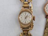 two ladies ' s wrist watches are sitting next to each other on a table