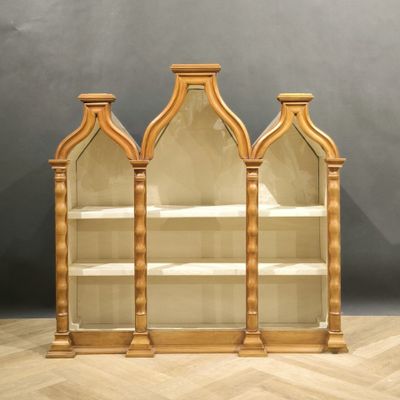 deux grandes étagères en bois avec des portes vitrées, posées sur un parquet