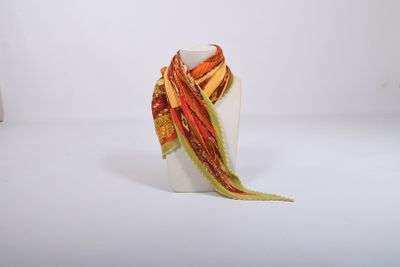 a white vase with a colorful scarf on top of it