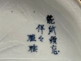 une assiette blanche sur laquelle figure une inscription en chinois