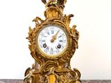 une horloge en or posée sur une table en marbre