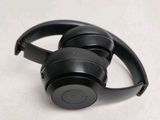a pair of black headphones on a white surface
