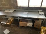 a metal work table with a bunch of boxes on it