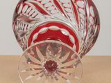 a red and white glass vase sitting on a table