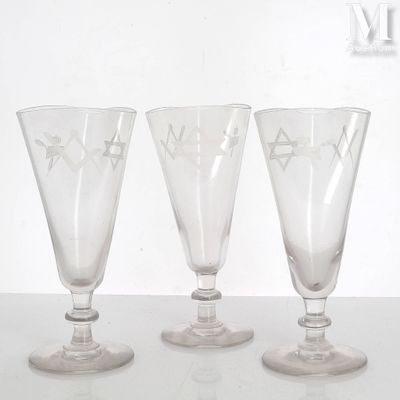 three wine glasses sitting on a table next to each other